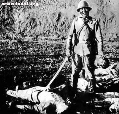 这个惨无人道的日本军官在杀死人后，提着一个砍掉的脑袋的耳朵，洋洋得意地照相.jpg.jpg